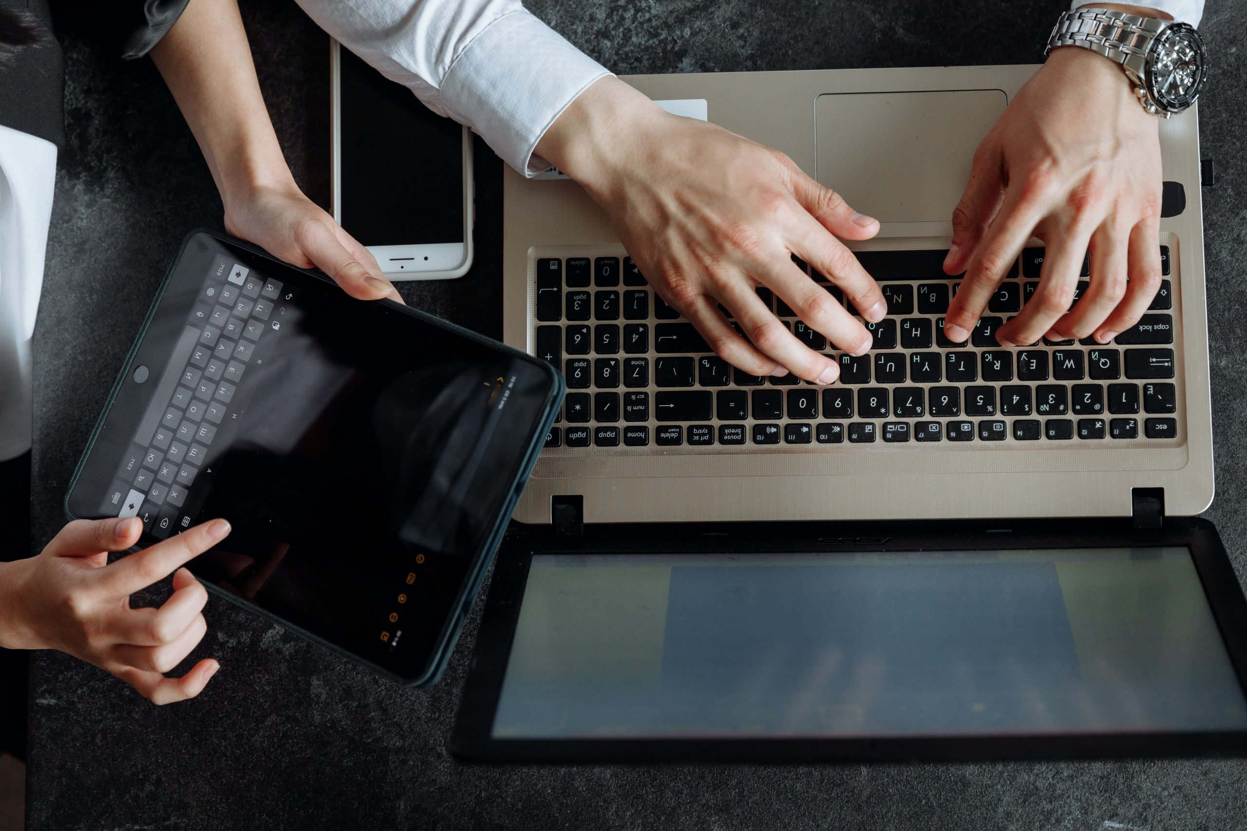 people working on multiple digital devices for marketing purposes